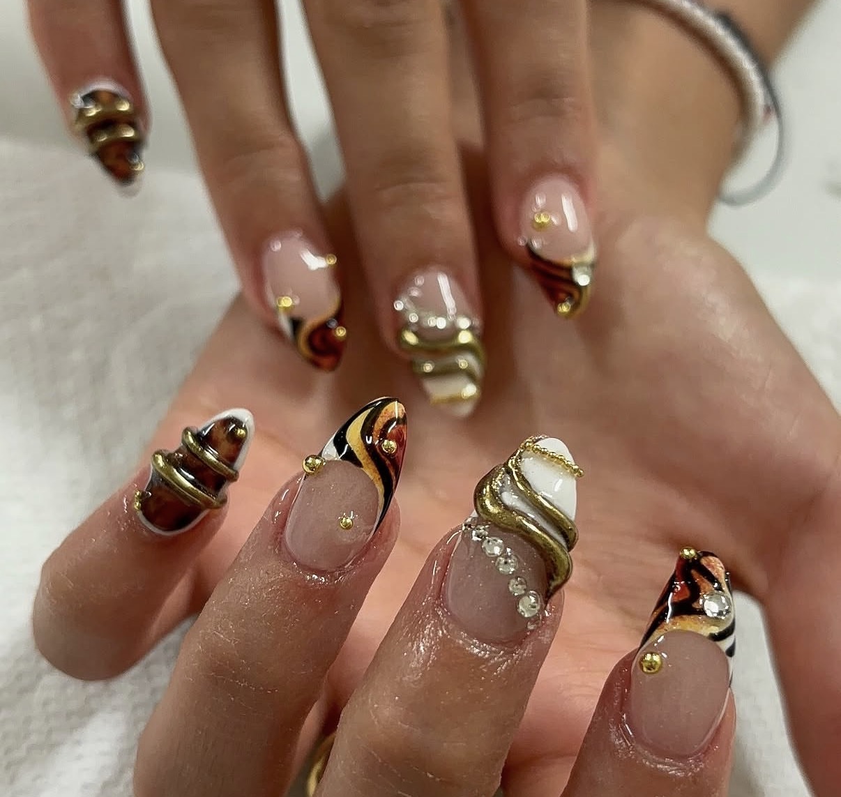 Ongles décorés de motifs écaille et de reliefs dorés